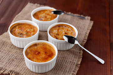 Creme brulee in a white bowl with sugar crust. Studio photography. country style.