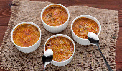 Creme brulee in a white bowl with sugar crust. Studio photography. country style.
