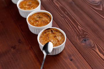 Creme brulee in a white bowl with sugar crust. Studio photography. country style.