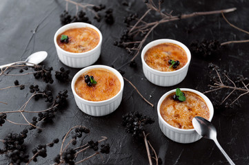 Creme brulee in a white bowl with sugar crust. Studio photography. country style.