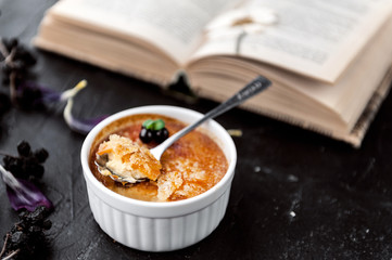 Creme brulee in a white bowl with sugar crust. Studio photography. country style.