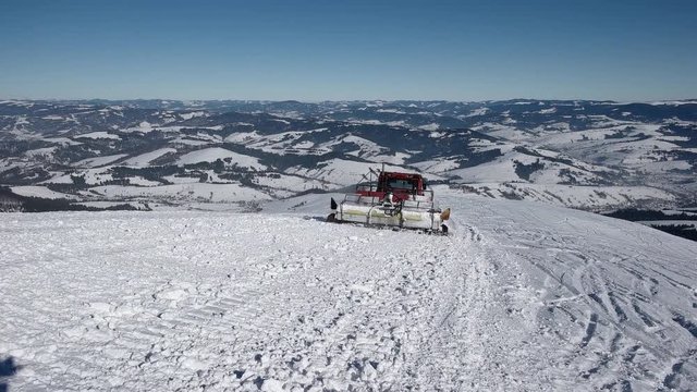 Skiers Riding on the Back of a Snowcat on a Snow Covered Mountain at a Winter Sunny Day