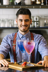 Barman is making cocktail at night club.