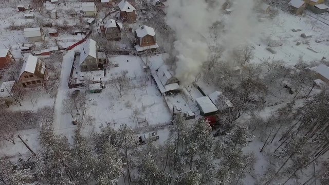 Aerial view house is on fire in a country town in the winter