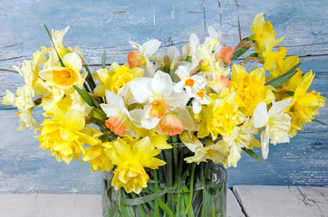 Duft- und Blütenrausch: leuchtend gelbe Osterglocken in Blumenvase vor blauem Holz :)
