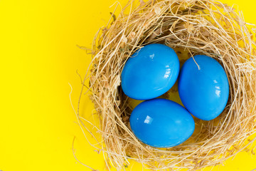 Fototapeta premium Easter eggs in nest on rustic wooden background, selective focus image. Happy Easter Card - space for text 