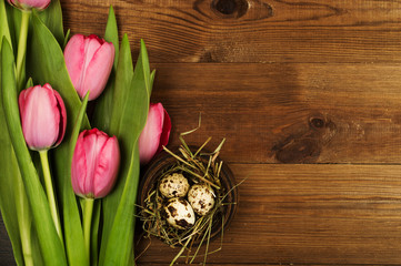Chicken and quail eggs with tulips. Easter background