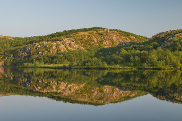 Calm lake in the summer and rocks.