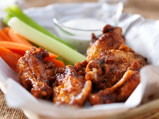 bbq buffalo chicken wings in basket, with ranch dip, carrot and celery sticks