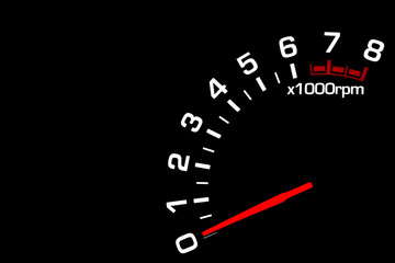 Close up shot of a car speedometer tachometer on black background