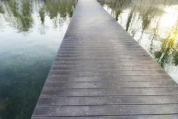 Infinity long pedestrian bridge over a lake with reflections