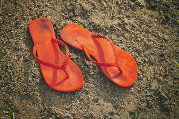 Pair of flip flops on the beach in the sunny afternoon.