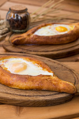 Ajarian khachapuri on wooden table. Traditional Georgian cuisine. cuisine of the Georgian people