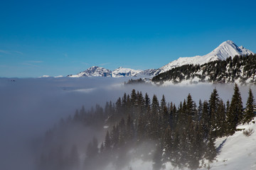 Mountains covered with snow and surrounded by clouds