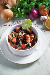 Paella in white plate with saffron rice, peas, shrimps, mussels, squid, meat. Seafood paella, traditional spanish dish.