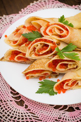 Rolls pancakes with red caviar. Russian cuisine. Flat lay. Maslenitsa. Wooden background. Top view. Close-up