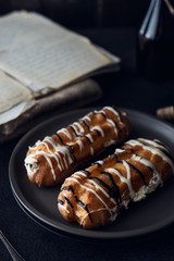 Sweet eclair dessert on black background