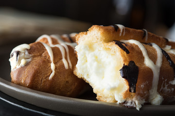 Sweet eclair dessert on black background