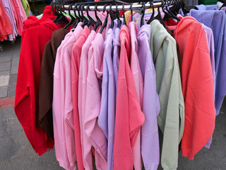 colorful sweatshirts for sale at an outdoor market