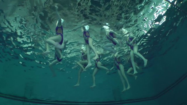 Synchronized swimming, team training, underwater view.
