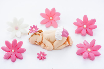 Fototapeta na wymiar Edible fondant sleeping baby girl and flowers cake topper for decoration cake