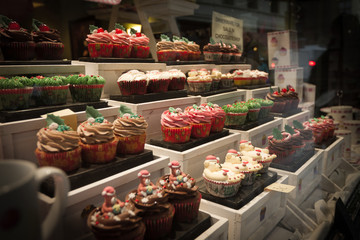 Display of colorful iced muffins in a bakery