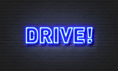 Drive neon sign on brick wall background.