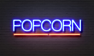 Obraz premium Popcorn neon sign on brick wall background.