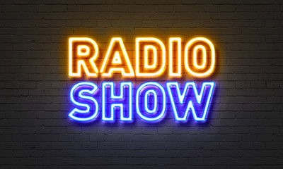 Radio show neon sign on brick wall background.
