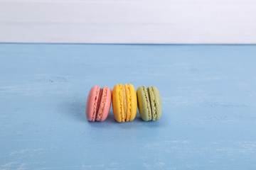 Macaroon cakes. Different types of macaron. Colorful almond cookies. On blue wooden rustic background.