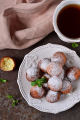Homemade donuts with powdered sugar for breakfast on the old grunge background