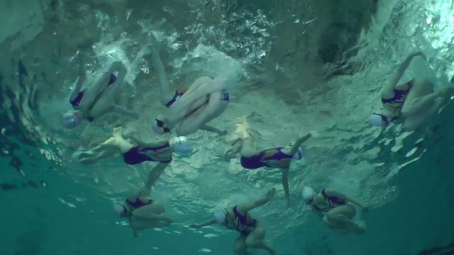 Synchronized swimming, team training, underwater view.

