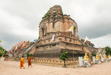  Chedi Luang Pagoda, two monks walking near the Temple with cloudy sky