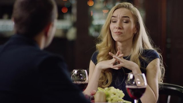 curling blondie beauty telling to partner in restaurant