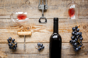Glasses of red wine and bottle on wooden background top view