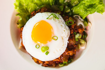 fried noodle with minced pork and fried egg on white dish
