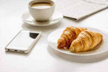 Breakfast for businessman with coffee and croissant on white table