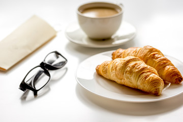 Breakfast for businessman with coffee and croissant on white table