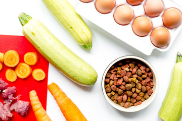 healthy dogfood with eggs, vegetables and meat on kitchen background top view