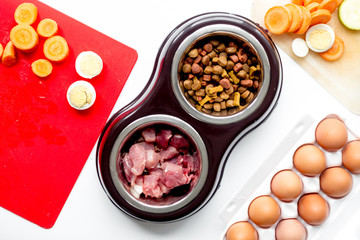 Dogfood, eggs, meat, carrot and courgette on table background top view