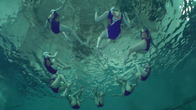 Synchronized swimming, team training, underwater view.
