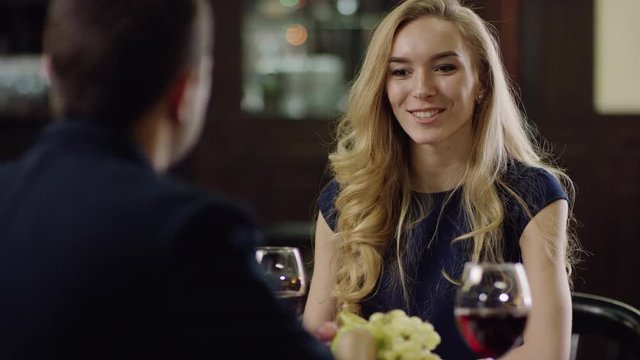 curling blondie beauty talking with partner in restaurant