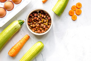 petfood set with vegetables and eggs on kitchen table top view mockup