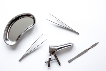 instruments of gynecologist on white background top view