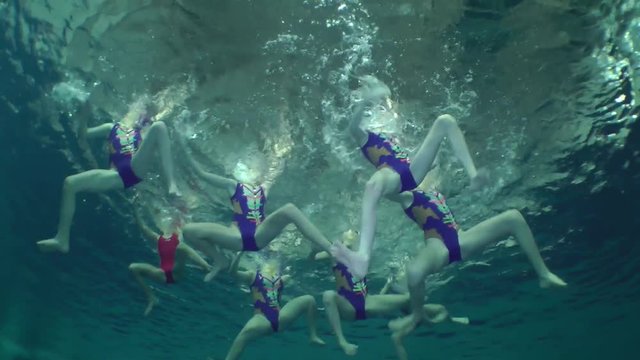 Synchronized swimming, team training, underwater view.
