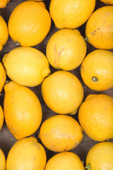 Ripe organic lemons in wooden vintage tray like background