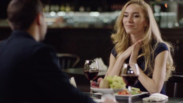 smiling cute lady sitting at the table with a man