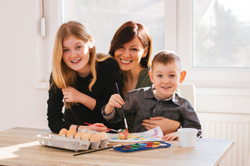 Mom painting with kids at home. Happy family time