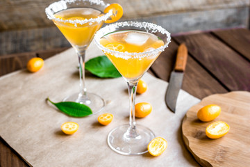 cocktail with kumquat on wooden background