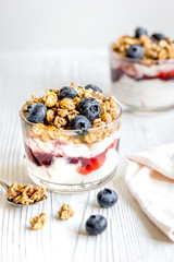 Morning granola with yogurt and berries on white kitchen background